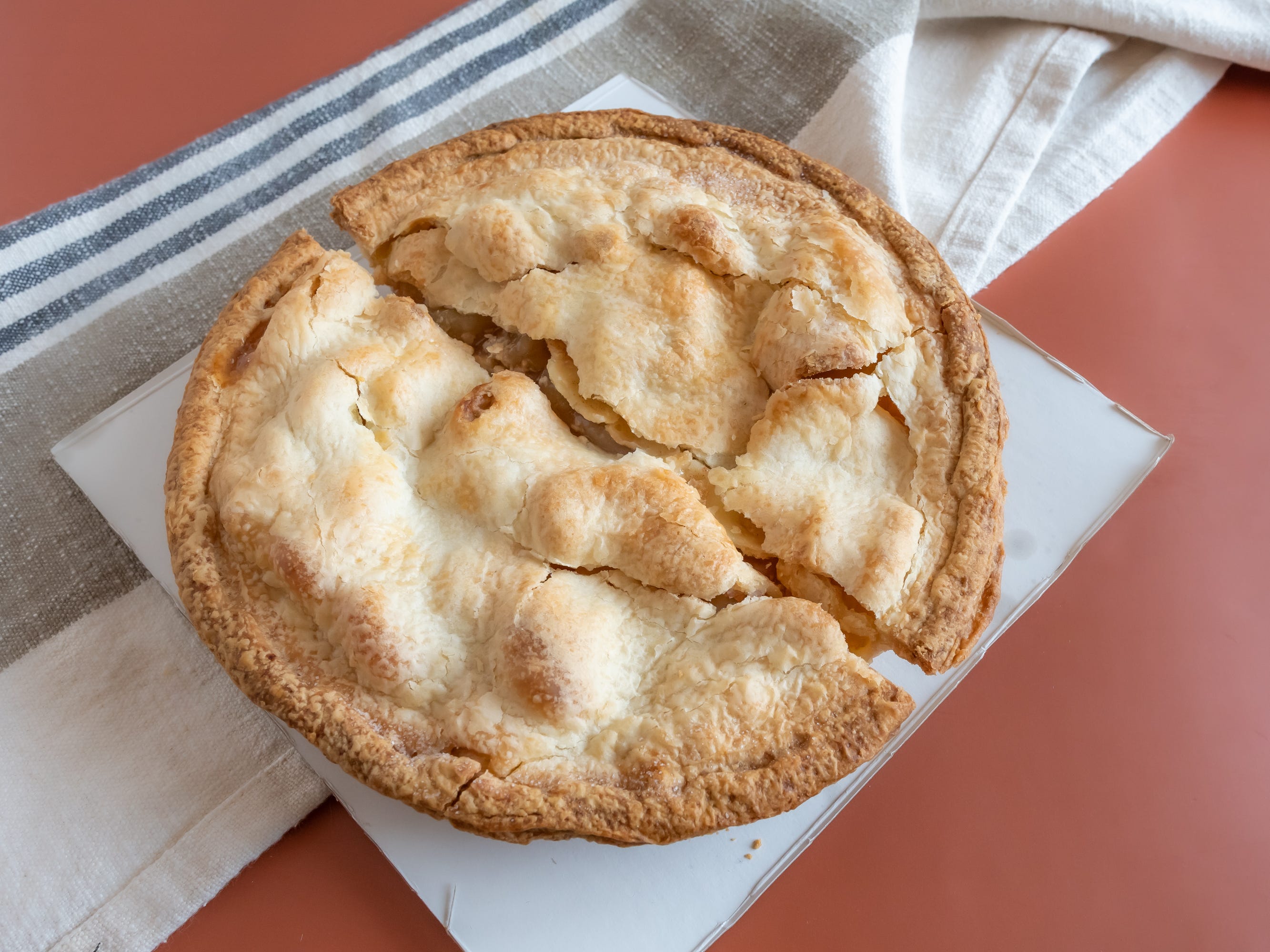 Whole apple pie from whole foods on red table