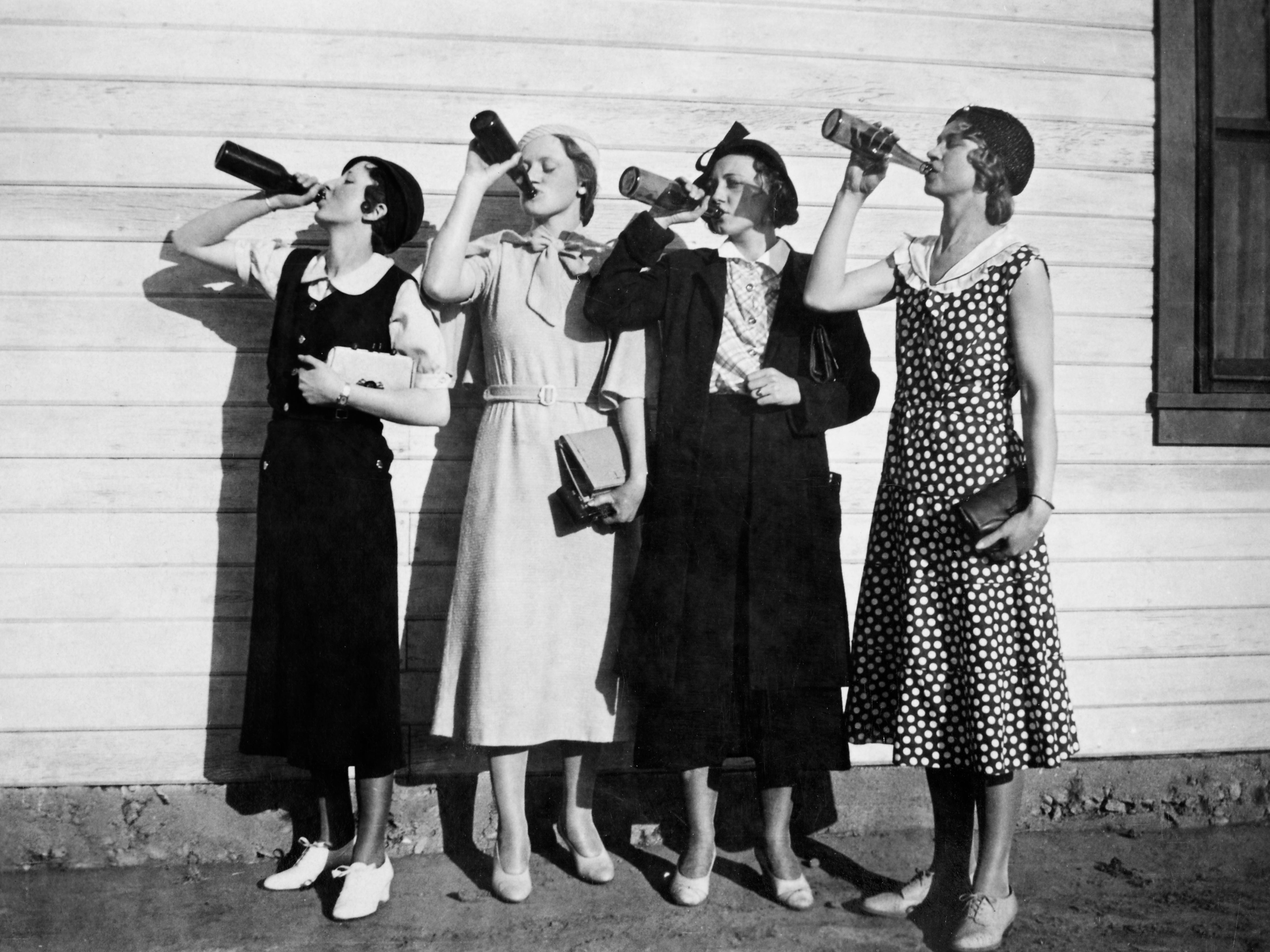 A group of four women drinking bottles of liquor in 1925.