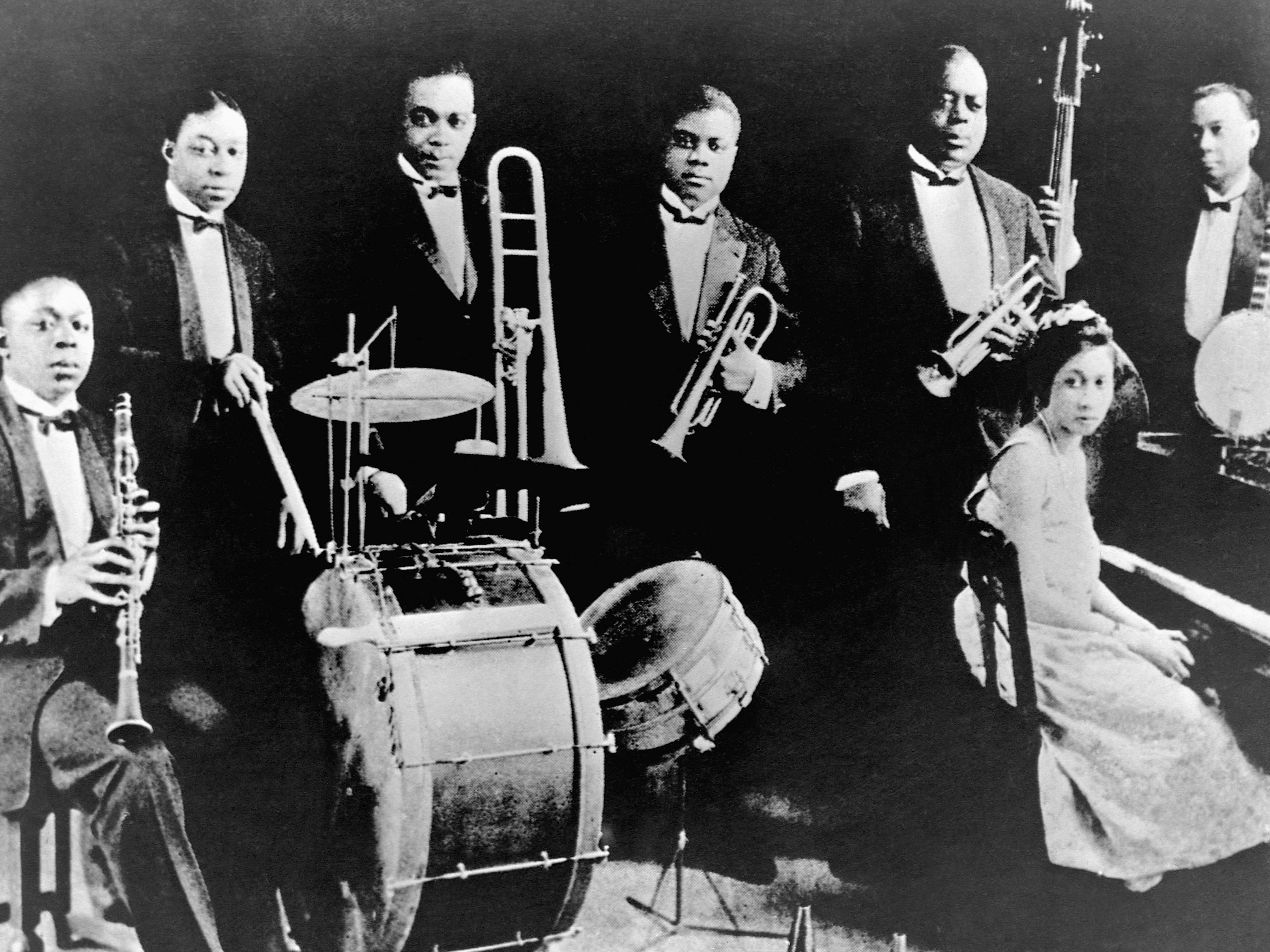 Joe "King" Oliver and his Creole Jazz Band posing in 1922. The band included: Johnny Dodds, clarinet; Baby Dodds, drums; Honore Dutrey, trombone; Louis Armstrong, second trumpet; King Oliver, lead trumpet; Lil Hardin, piano; and Bill Johnson, banjo.