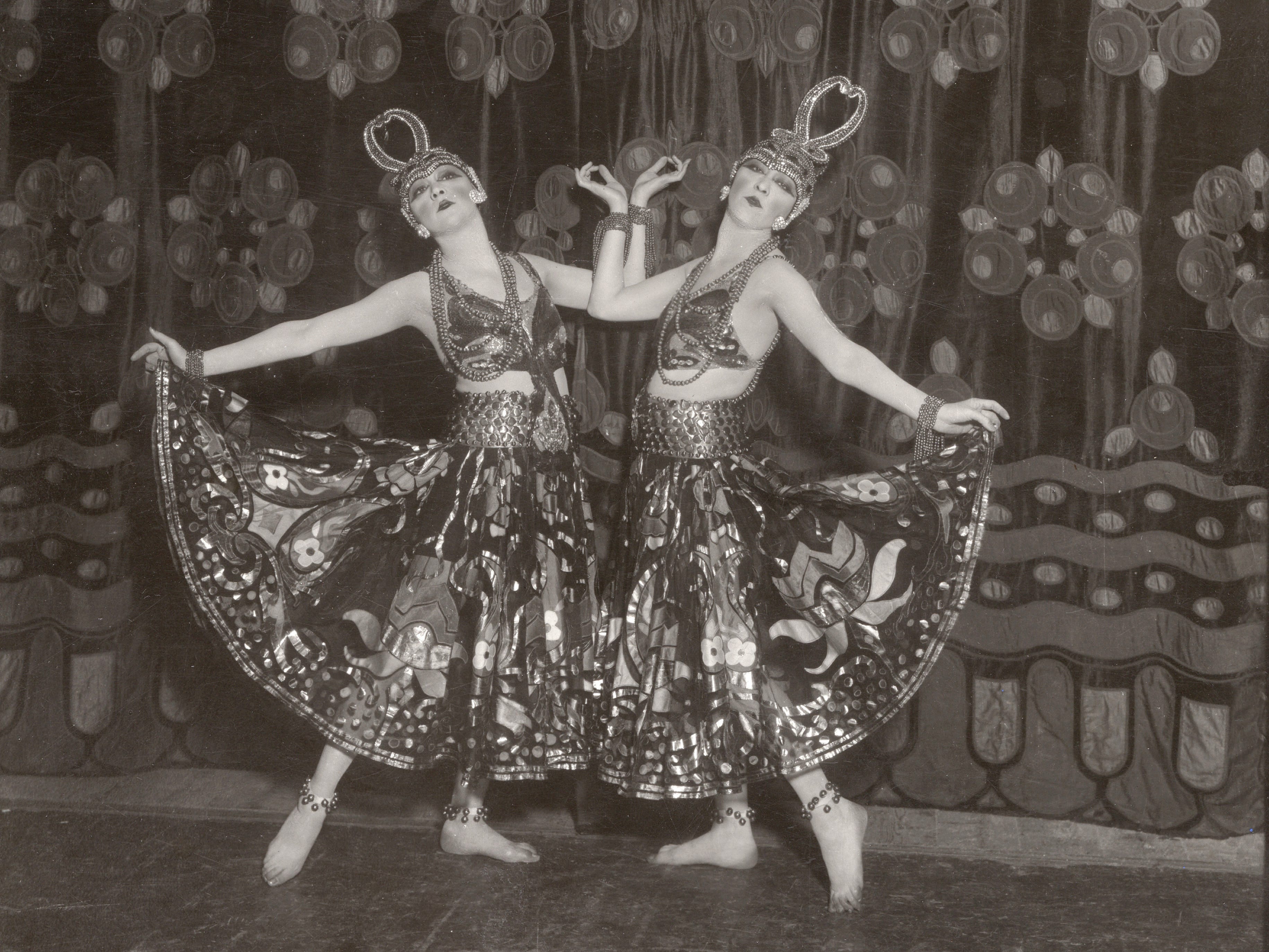The Dolly Sisters on stage in the 1920s. They wore elaborate, detailed costumes and headpieces.