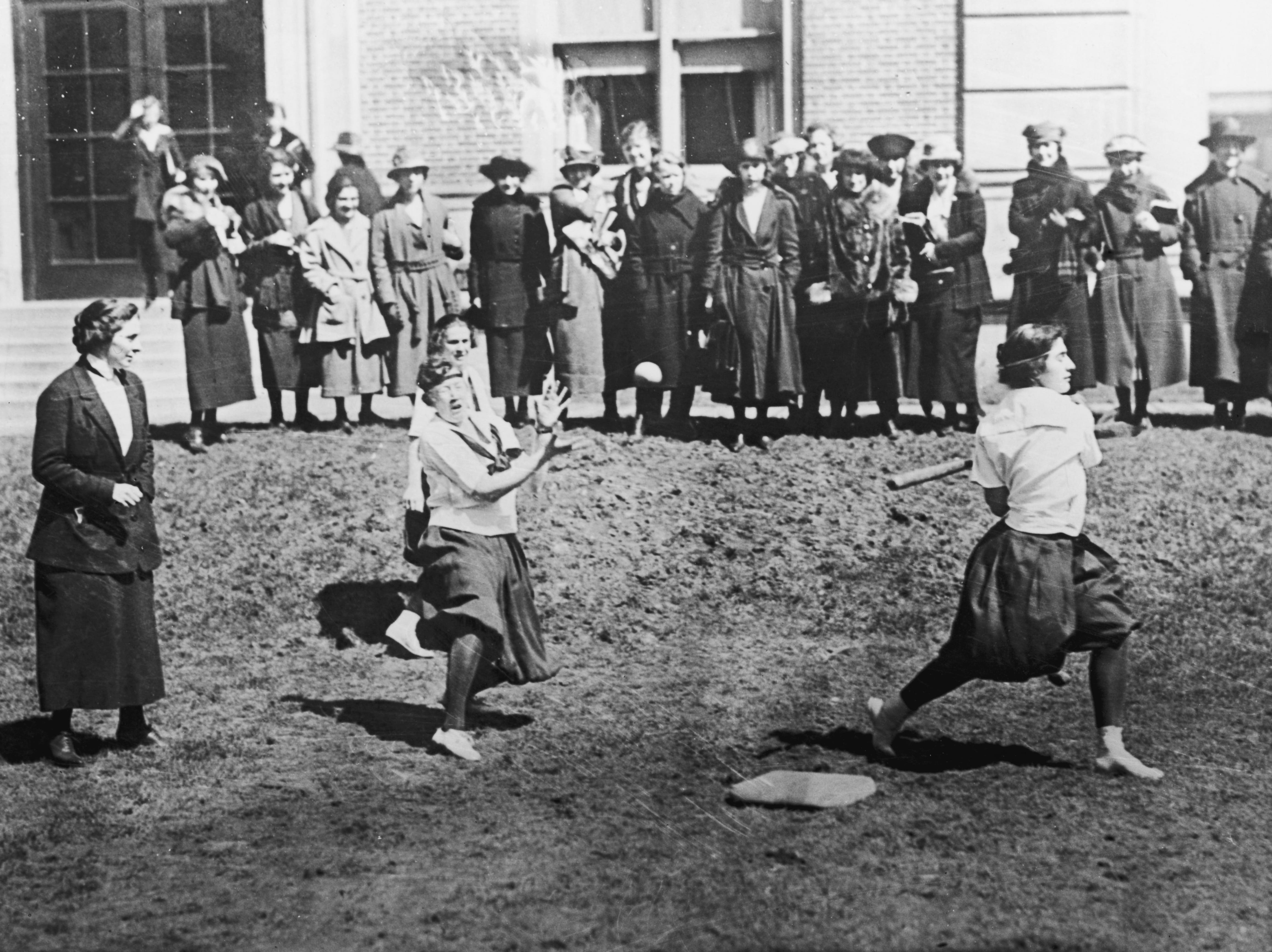 Barnard College's baseball team training in 1925 as others watched nearby.