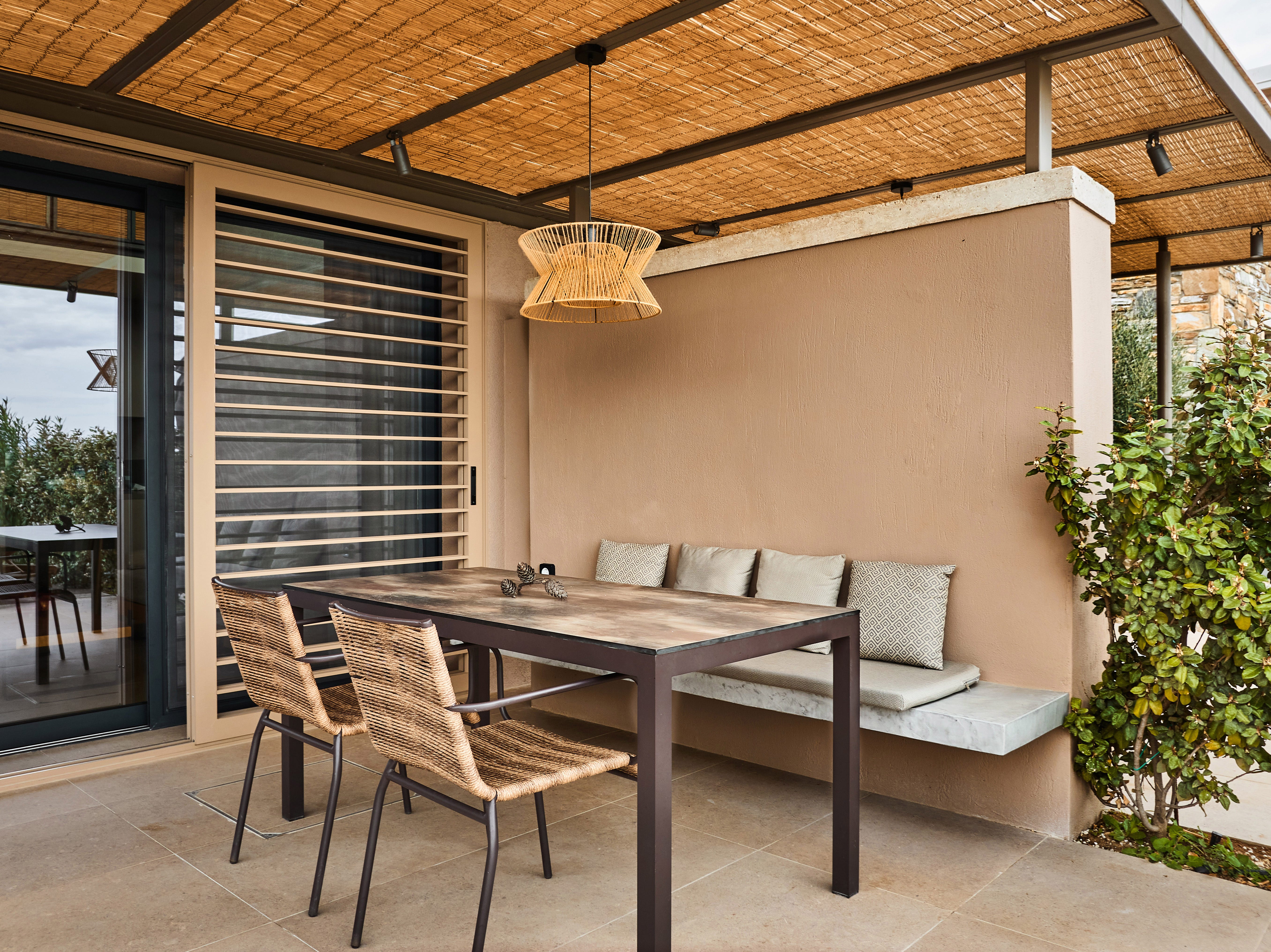 Lamp hanging from pergola in yard with seating below it