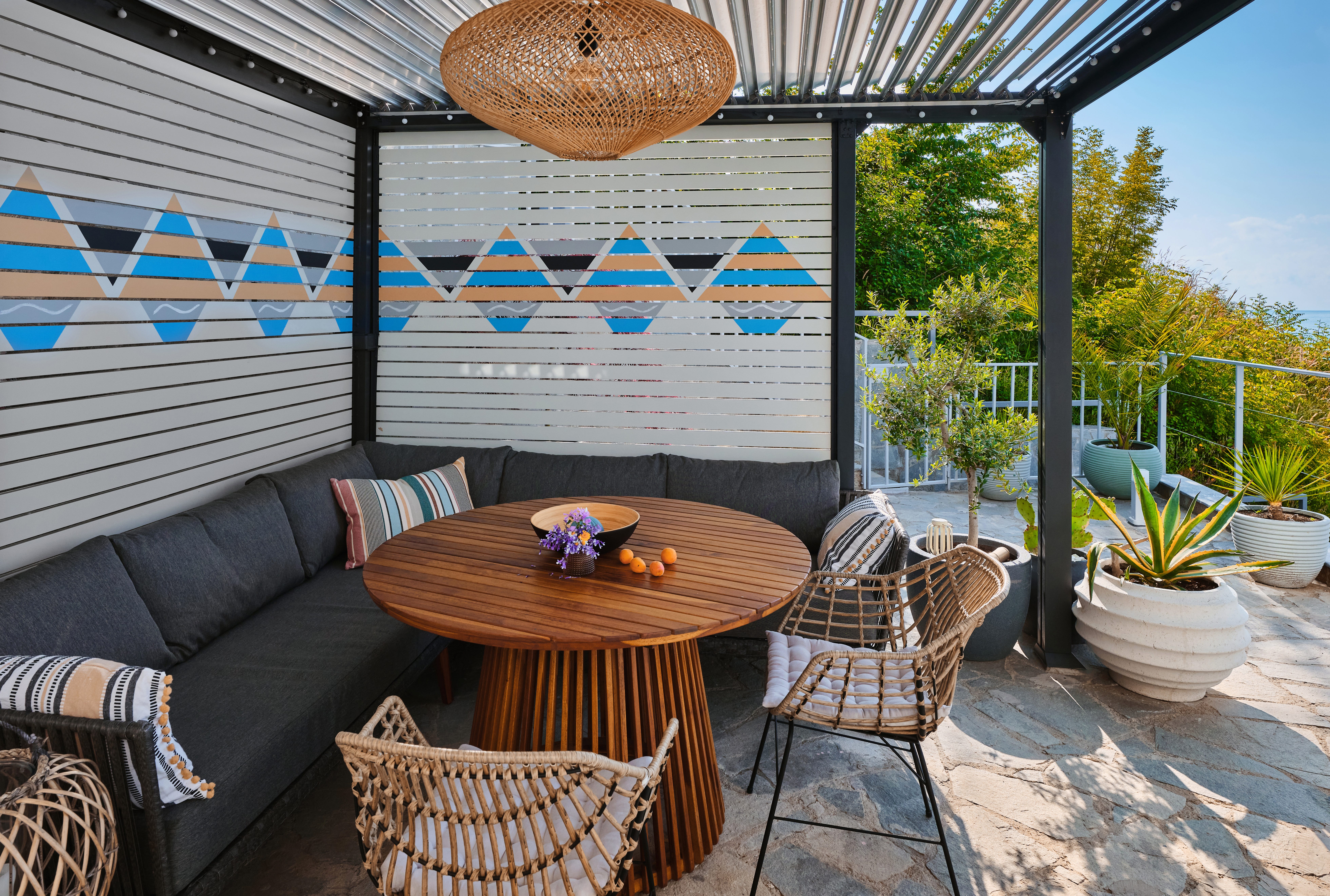 Outdoor furniture area with painted slat walls, round table, stone patio