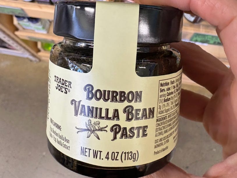 A hand holding Trader Joe's bourbon vanilla bean paste.