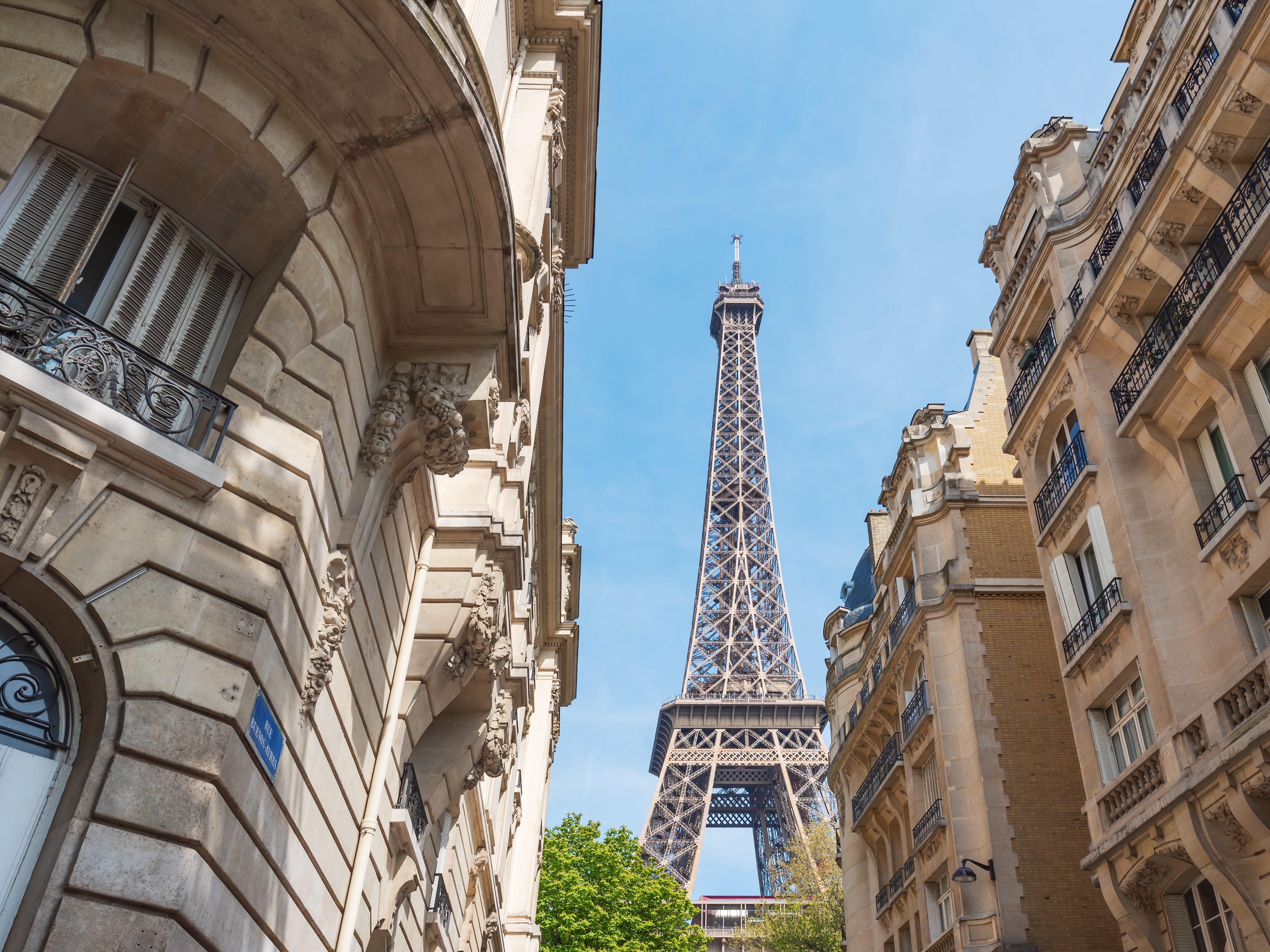 A view of the Eiffel Tower between buildings.