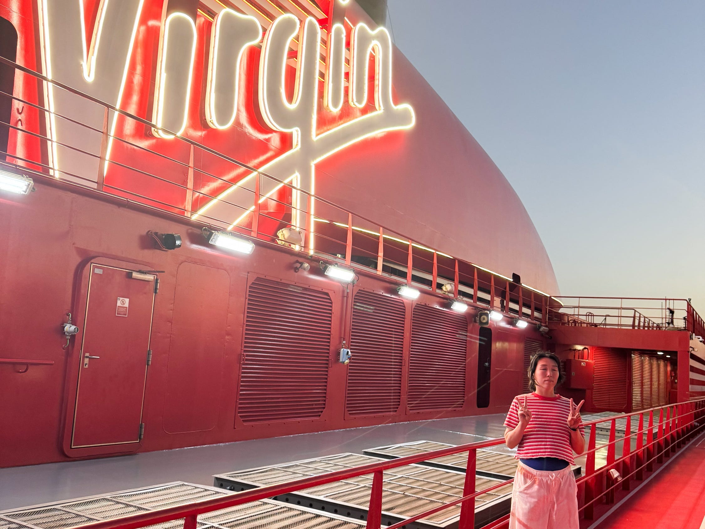 The writer poses on the deck of a Virgin Voyages cruise ship.