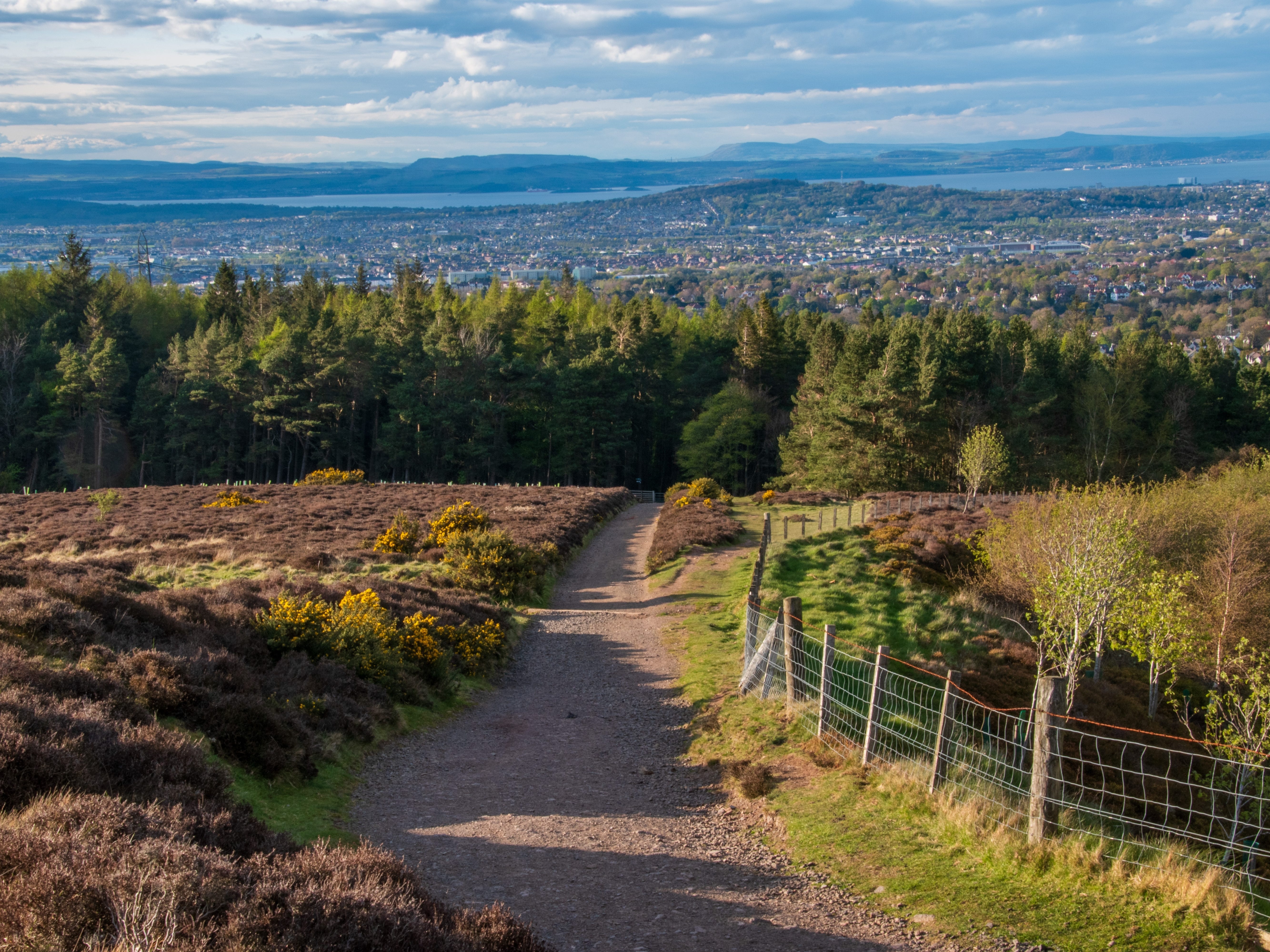 A path at the bottom of Pentland Hills with Edinburgh in the distance.